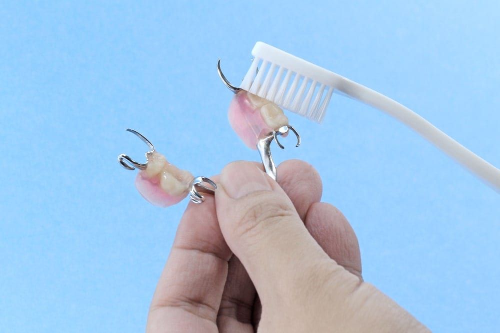 Toothbrush cleaning partial denture